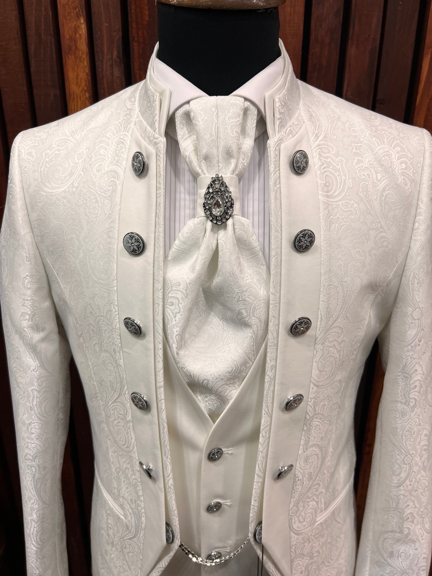 Men's white floral tuxedo with mandarin collar, featuring elegant detailing and buttons, ideal for weddings and galas.