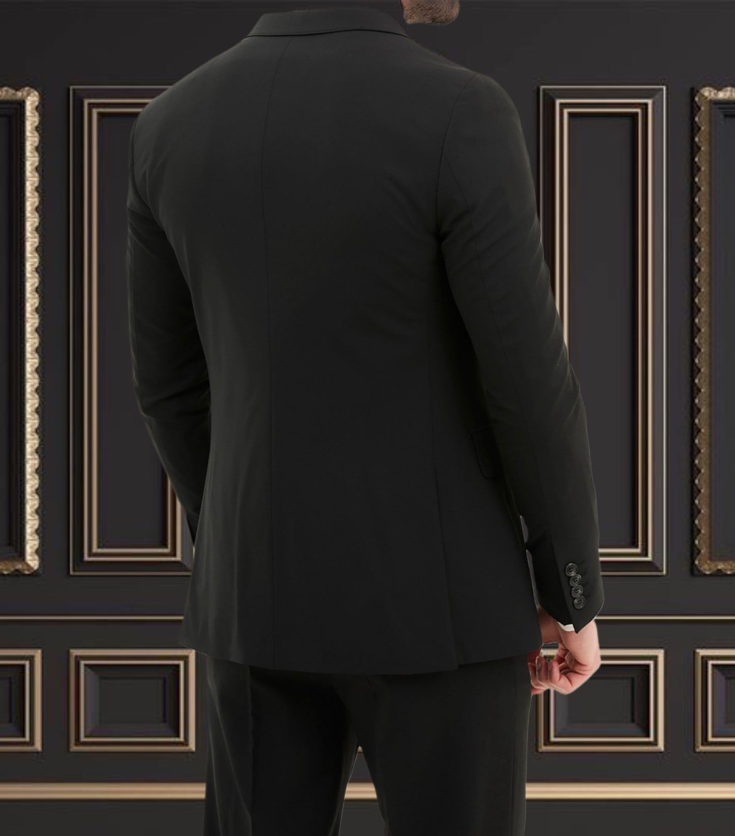 Back view of a man wearing a sleek black slim fit suit against a luxurious wall decor.