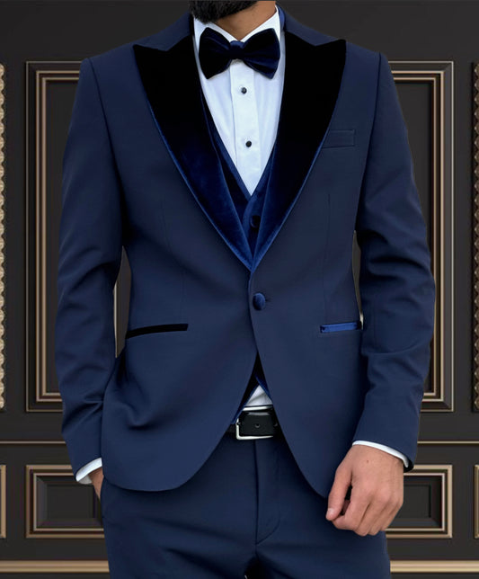 Men's navy blue tuxedo with velvet peak lapel, ideal for weddings and formal events, showcasing slim fit style.