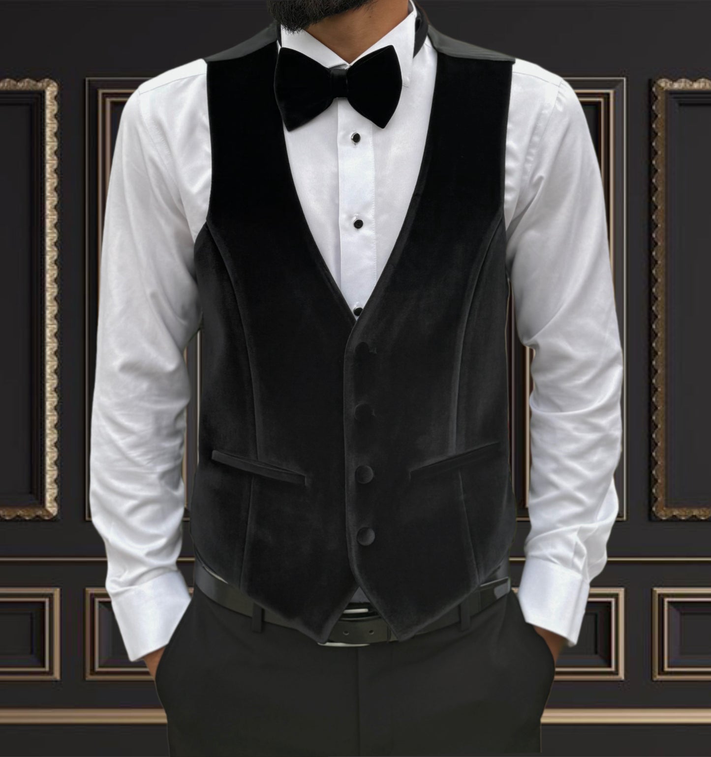 Men's black velvet vest worn with a button-up shirt and bow tie, perfect for formal occasions and events.