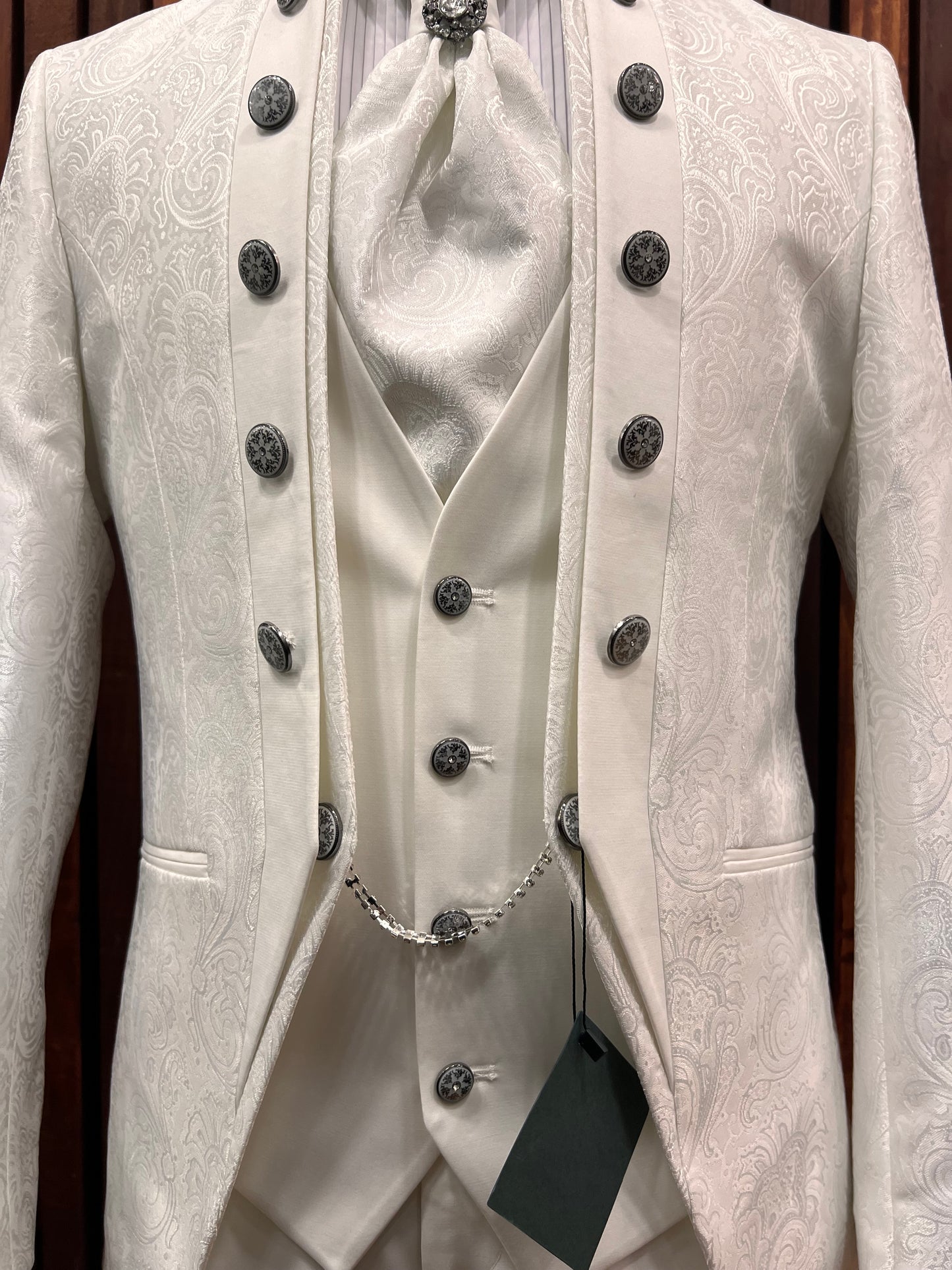 Men’s elegant white floral tuxedo with mandarin collar, featuring intricate button details and matching vest for formal events.