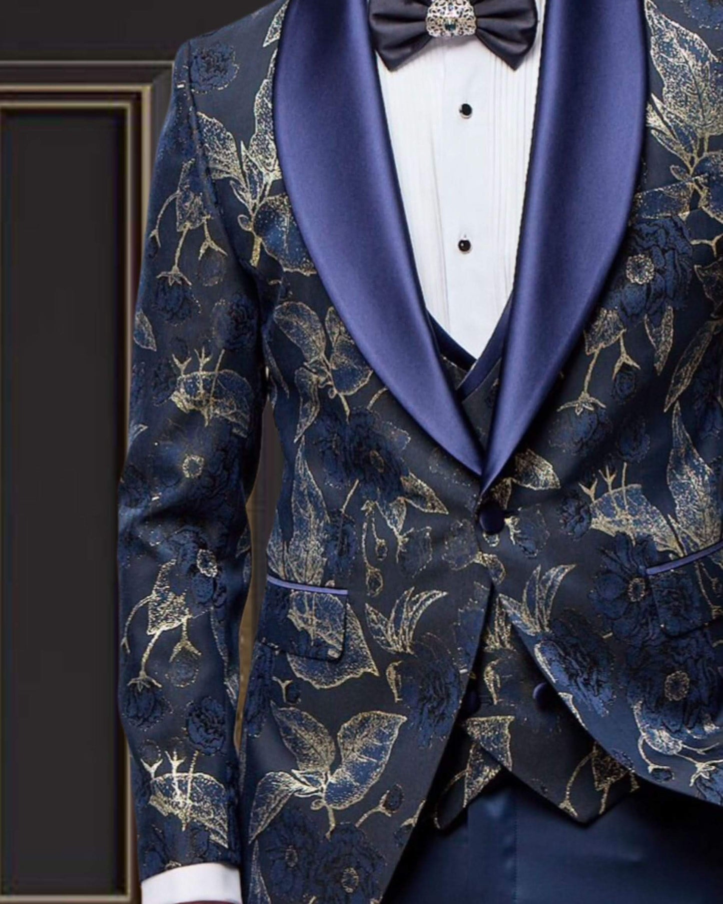 Stylish men's blue and gold floral tuxedo with shawl lapel for weddings and proms, showcasing elegant fabric design.